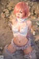 A woman with pink hair wearing a blue and white lingerie.