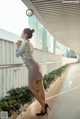 A woman leaning against a railing on a sidewalk.