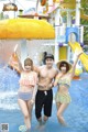 A man and two women standing next to each other in a water park.