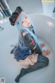 A woman with blue hair sitting in a bathtub.