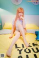 A woman sitting on a bed with her legs crossed.